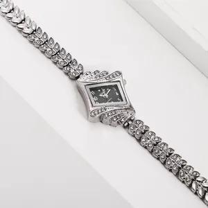 Detail of silver leaf-shaped bracelet watch with diamond accents and black rhombus dial