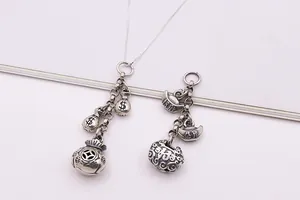 Vue macro de pendentifs rétro en argent S925 en forme de sac d'argent et de serrure