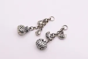 Gros plan de pendentifs en argent sterling S925 en forme de sac d'argent avec glands