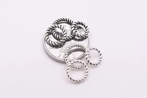 Makro-Detail von S925-Silber-Torsionsperlen für DIY-Schmuck mit Größenvergleichsmünze