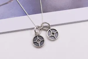 Gros plan de pendentifs pièces en argent sterling S925 avec finition vintage