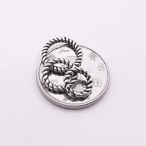 Dreiteiliges Set aus S925 Sterlingsilber geflochtenen Ringen auf einer Münze als Skala