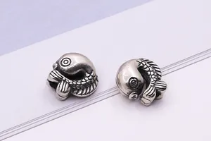 Macro shot of two vintage S925 sterling silver koi fish beads with detailed scales for DIY