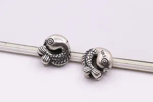 Macro detail of vintage S925 sterling silver koi fish beads showing fish scale texture