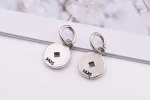 Détail macro de pendentifs ronds en argent sterling S925 avec trou carré vintage