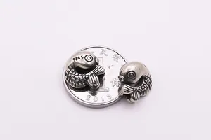 Macro shot of S925 sterling silver koi fish beads with coin for size reference