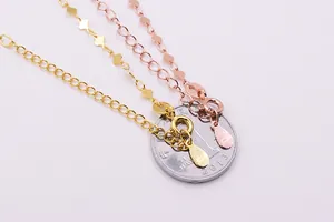 Macro detail of S925 sterling silver heart chains and lobster clasp with coin for scale