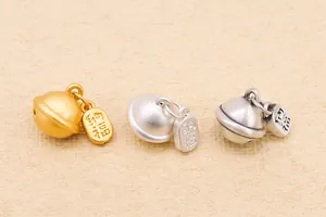 Dettaglio di ciondoli a campanello in argento S999 con amuleti in tre finiture metalliche