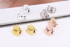 Detailed macro view of S925 sterling silver flower-shaped earring backs in three colors