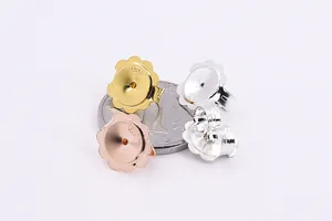 Detailed comparison of S925 silver flower earring lifters against a coin for size reference