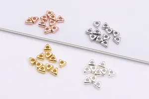 Detalle macro de cuentas triangulares de plata de ley S925 en cuatro colores para DIY