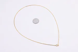 Detailed shot of 0.8mm gold S925 silver chain with 45cm length next to a coin