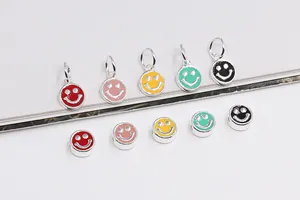 Macro-opname van kleurrijke emaille smiley hangers en zilveren kralen voor sieraden