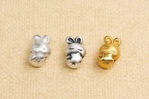 Makroansicht von DIY-Anhängerperlen in Hasenform in Silber und Gold mit kleinen Sternen