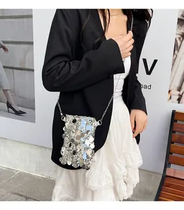 Petit sac de téléphone argenté à paillettes avec bandoulière chaîne sur un mannequin