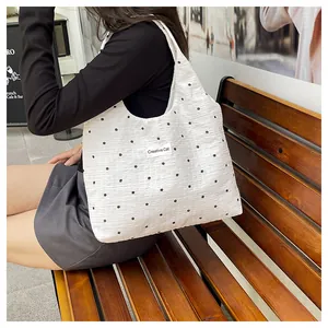Detalle de bolso tote plisado blanco con estampado floral y logo Creative Cat