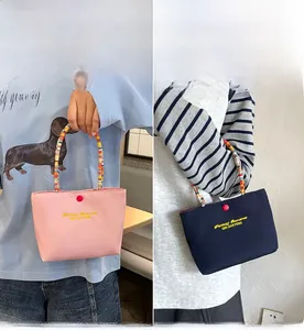 Detail of pink and navy embroidered mini handbags with colorful beaded handles and red button
