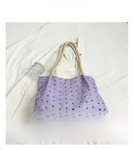 Detail of purple tote bag featuring black bow patterns and textured bubble fabric