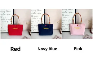 Detailed view of embroidery on canvas tote bags in red, navy blue, and pink colors