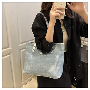 Detailed view of light blue shimmering tote bag with silver handles and metallic texture
