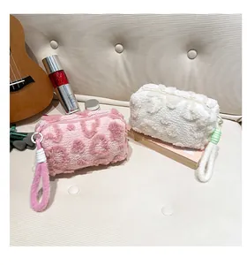 Close-up of plush heart pattern cosmetic bags with soft fleece texture and zipper handle