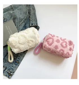 Detail of plush lamb wool makeup bags with embossed heart patterns in white and pink