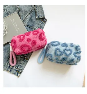 Detail of plush heart-pattern cosmetic bags in pink and blue sherpa fleece texture