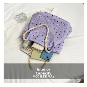 Internal capacity of large purple tote bag with bow detail and daily essentials