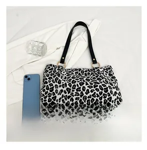 Fashion zebra print tote bag with black straps and metal rings, shown beside a mobile phone