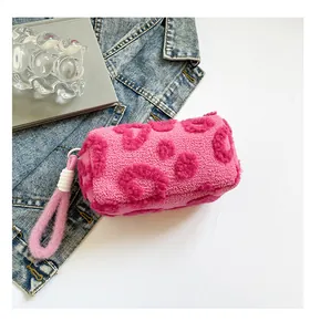 Close-up detail of plush rose pink faux fur makeup bag with leopard heart patterns