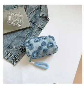 Detail of soft blue plush cosmetic bag with navy hearts and lamb-like texture