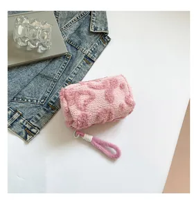 Detailed macro of pink plush cosmetic bag with 3D floral pattern and zipper puller