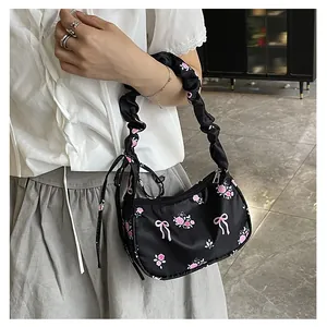 Close-up of floral canvas shoulder bag with pink roses and ruffled scrunchie handle