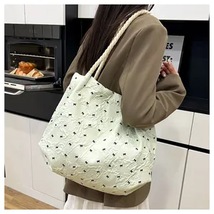 Detail of light green bow tote bag with soft cloud quilting and woven cotton rope handles