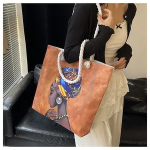 Canvas tote bag with African art print and thick cotton rope straps worn by a model