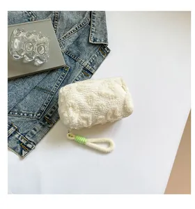 Close-up of plush white makeup bag with textured hearts and green string detail