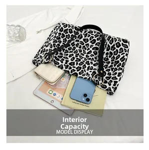 Detail showing internal capacity of zebra print tote bag with tablet and wallet