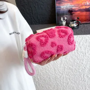 Plush pink makeup bag with heart patterns and soft faux fur handle for travel
