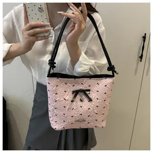 Detailed view of pink floral jacquard bucket bag with black bows and heart pendant