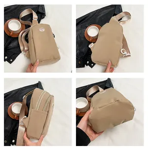 Detail view showing multi-angle cream nylon sling bag with wide straps and zippers