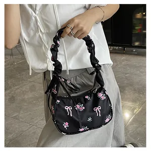 Detail of floral canvas bag featuring pink roses, bow prints and ruffled shoulder strap
