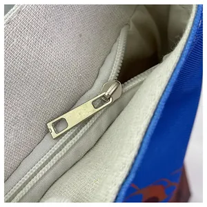 Detailed macro view of the silver metal zipper and blue canvas fabric on a tote bag