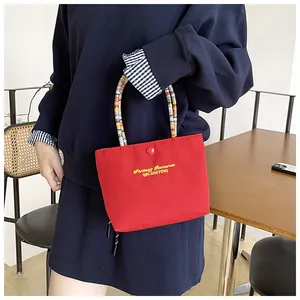 Detail of red embroidered handbag with beaded handle and Fantasy Romance text