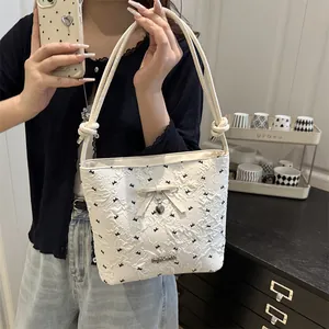 White bucket bag with heart prints, bow decoration, and fashion metal plate detail