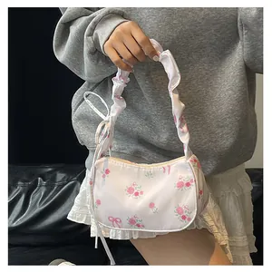 Detail of floral printed canvas bag with pink roses, bow patterns and ruched handle