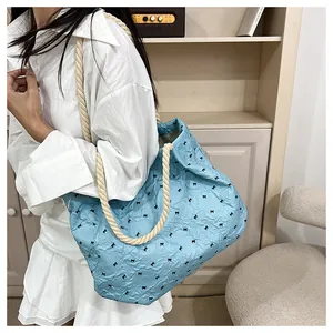 Detail of light blue tote bag with black bow patterns and thick cotton rope handle