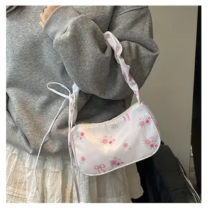 Detail of floral canvas bag featuring pink rose patterns and soft satin texture on shoulder
