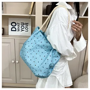 Detail of light blue bow print tote bag with thick cotton rope handles in a lifestyle setting