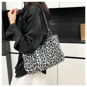 Detail of zebra pattern tote bag with black leather strap and gold ring connector