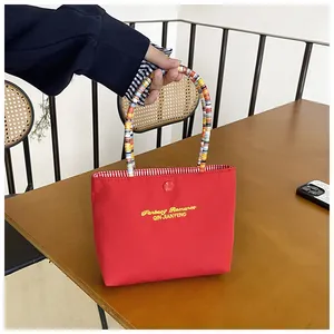 Detail of red canvas tote bag with woven handles, magnetic closure and striped lining